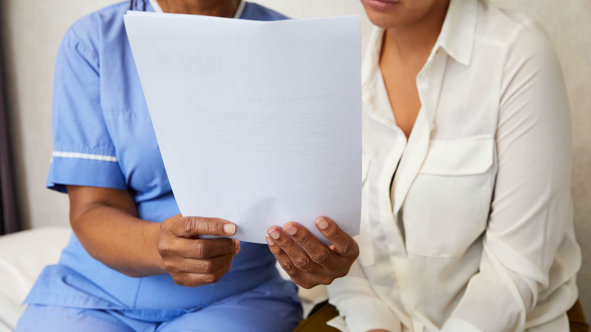 Midwife with patient reviewing documentation